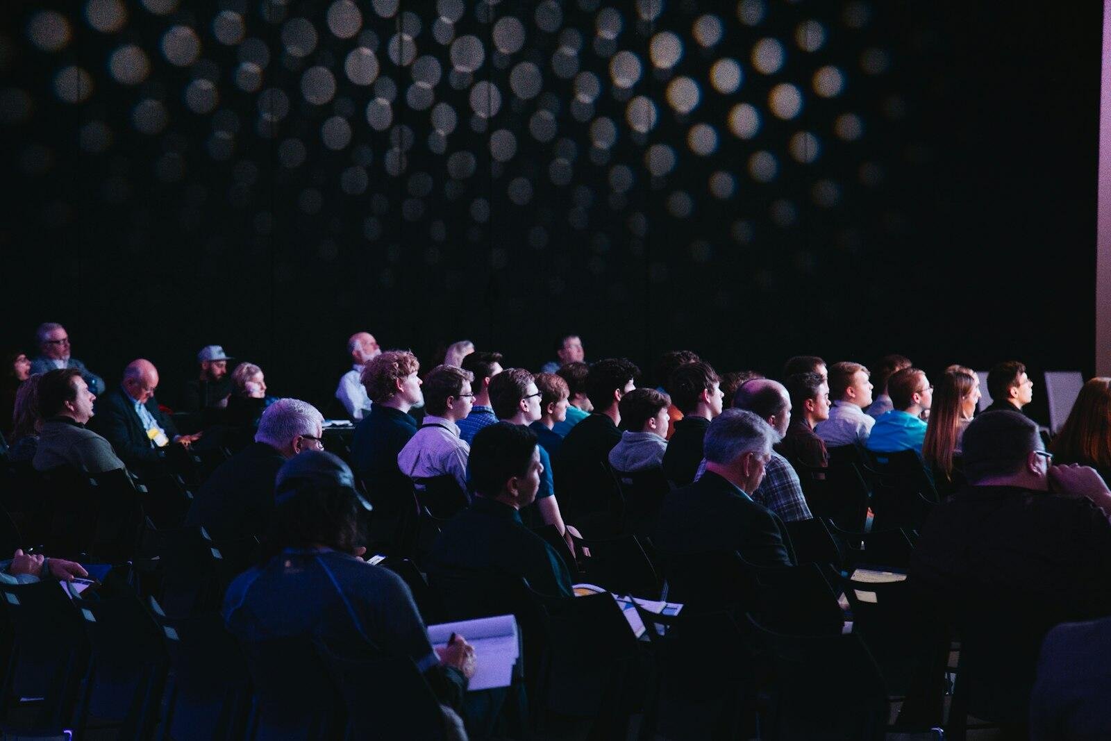 Event audience in front of a decorative lit backdrop